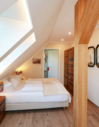 sichtbarer Holzbalken und zwei Dachfenster im Wohn- und Schlafraum, direkt unter dem Rohrdach