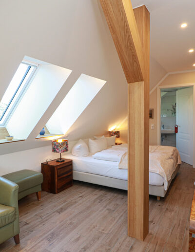 sichtbarer Holzbalken und zwei Dachfenster im Wohn- und Schlafraum, direkt unter dem Rohrdach