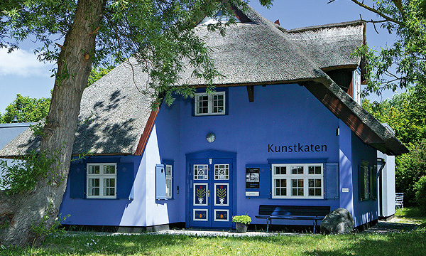 kleines, blaues Haus mit Reetdach und bunter Holztür, Kunstkaten Ahrenshoop