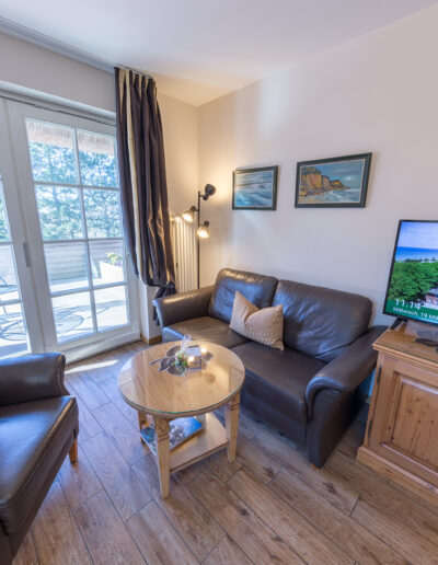 Juniorsuite, Blick auf gemütlichen Sitzbereich vor großem Balkon mit Blick ins Grüne