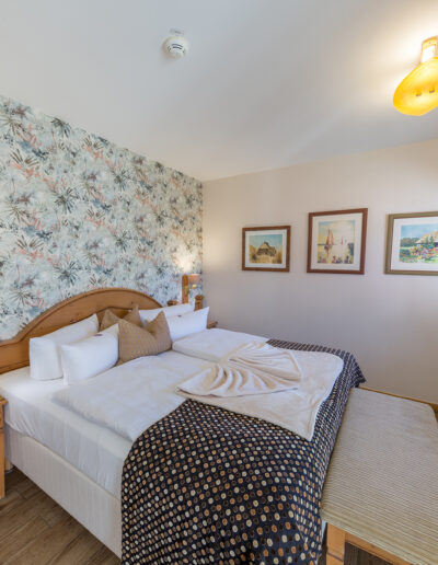 Doppelbett in Juniorsuite mit Leselampen und Fußbank