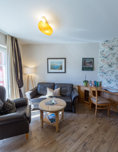 Juniorsuite, rechts: großer Schreibtisch, links: Sitzbereich mit Zugang zum Balkon