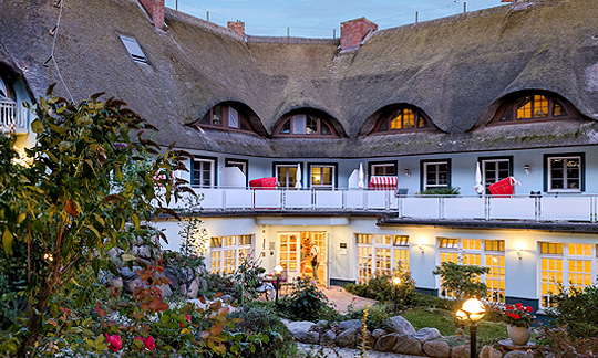 Romantik Hotel Fischerwiege Romantik Hotel Fischerwiege, Reetgedecktes, hellblaues Haus mit Rundbogenfenstern und Balkonen